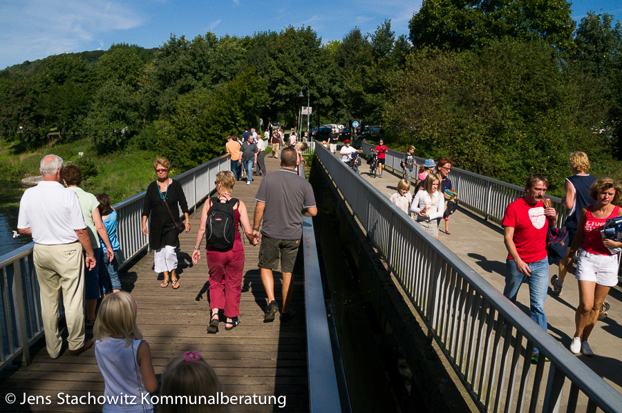 Fußgängerbrücken über den Oelbach ist gefüllt mit Menschen.