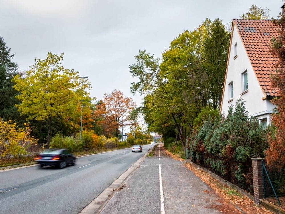 Vierspurige Hauptverkehrsstraße und Einfamilienhaus nebendran