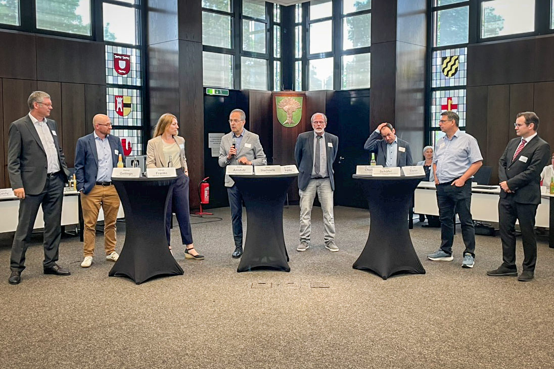 Diskutierende im Halbrund stehend